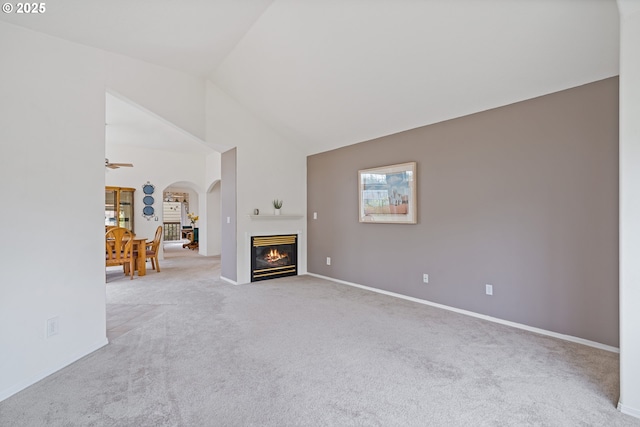 1939 NE Harewood Pl, Hillsboro, OR 97124 - carpeted living room with arched walkways, baseboards, vaulted ceiling, and a glass covered fireplace