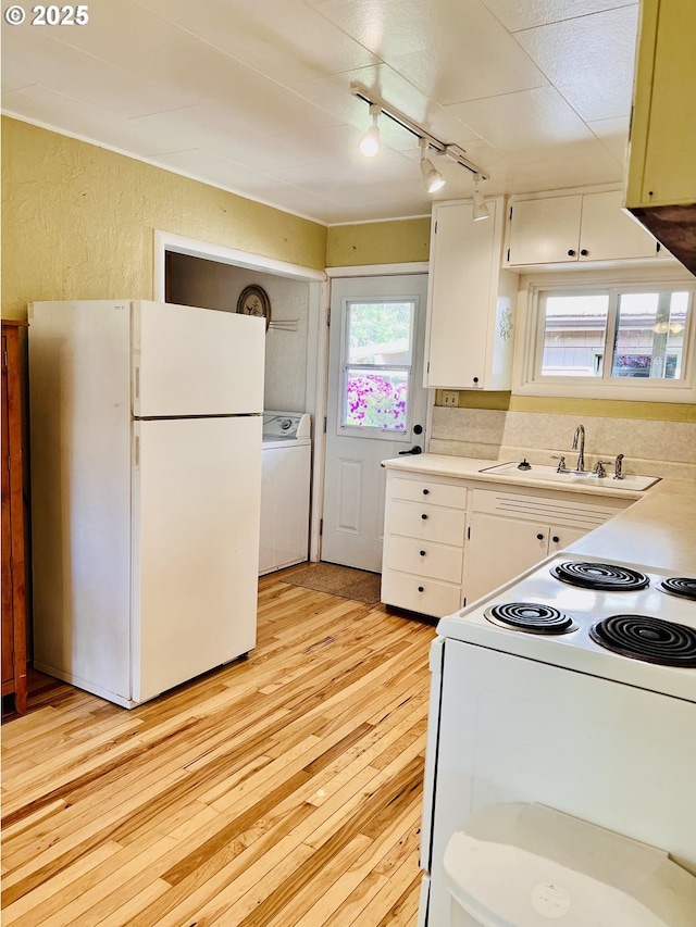 42799 Leaburg Dr, Walterville, OR 97489 - kitchen featuring rail lighting, a sink, washer / dryer, white appliances, and light wood-style flooring