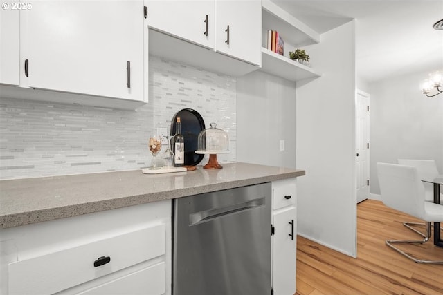 2450 Eddy Ave NE, Salem, OR 97301 - kitchen with stainless steel dishwasher, tasteful backsplash, light wood finished floors, white cabinets, and a chandelier