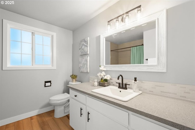 2450 Eddy Ave NE, Salem, OR 97301 - bathroom with vanity, baseboards, wood finished floors, toilet, and tasteful backsplash