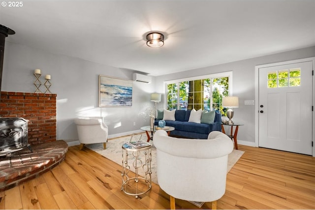2450 Eddy Ave NE, Salem, OR 97301 - living area with a wood stove, an AC wall unit, wood-type flooring, and baseboards
