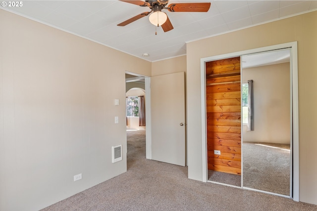 4656 Ocean Beach Hwy, Longview, WA 98632 - unfurnished bedroom with carpet flooring, arched walkways, crown molding, a closet, and a ceiling fan