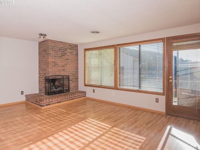 unfurnished living room with a fireplace and hardwood / wood-style flooring