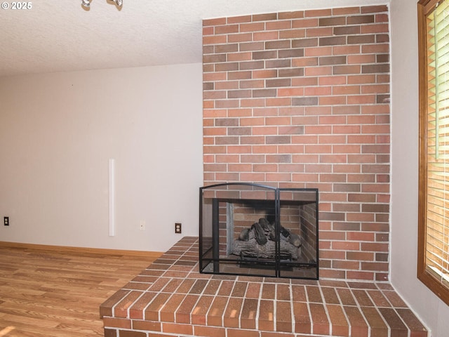 room details with hardwood / wood-style floors, a fireplace, and a textured ceiling