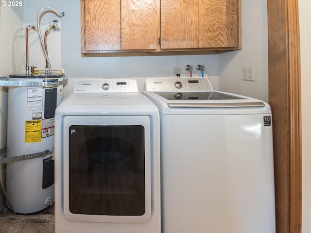 washroom with water heater, cabinets, and independent washer and dryer