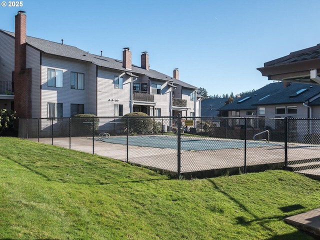 view of basketball court with a yard and an empty pool