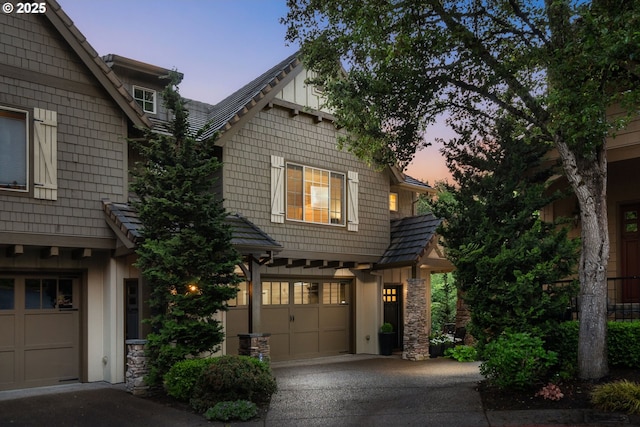 craftsman house with driveway, board and batten siding, and stone siding