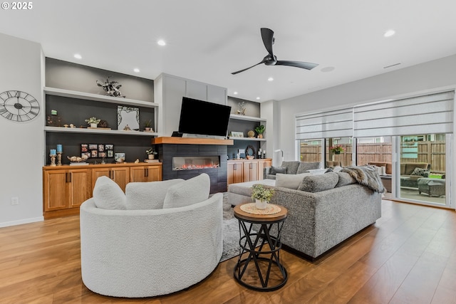 18500 NE 79th St, Vancouver, WA 98682 - living area featuring a glass covered fireplace, light wood-style flooring, a ceiling fan, built in shelves, and recessed lighting