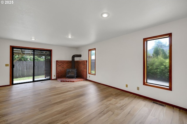915 Marquet Way, Eugene, OR 97401 - unfurnished living room with a wood stove, light wood-type flooring, baseboards, and recessed lighting