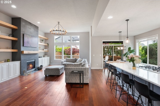 14925 SE Pebble Beach Dr, Happy Valley, OR 97086 - living room featuring baseboards, dark wood-type flooring, a tiled fireplace, recessed lighting, and a chandelier