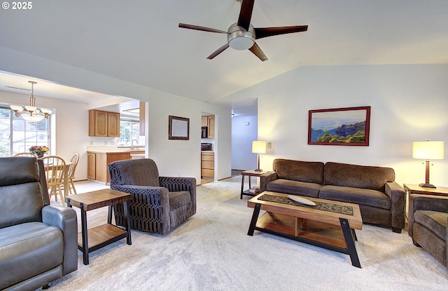 living room with light carpet, ceiling fan with notable chandelier, and vaulted ceiling