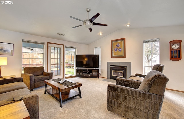 living area with lofted ceiling, plenty of natural light, and light colored carpet