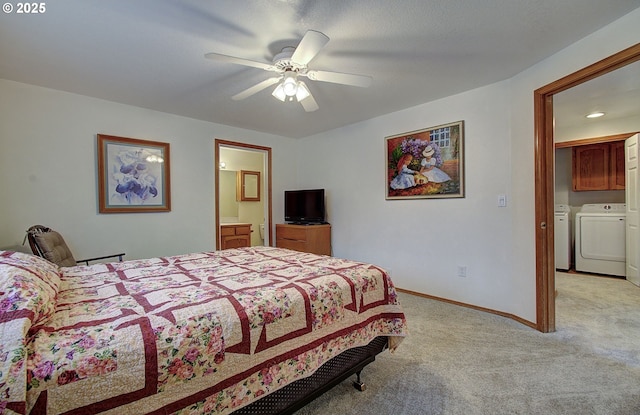 bedroom featuring a ceiling fan, baseboards, separate washer and dryer, ensuite bathroom, and light colored carpet