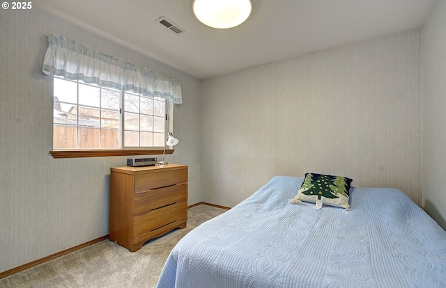 bedroom featuring visible vents, light colored carpet, wallpapered walls, and baseboards