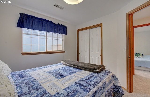 carpeted bedroom featuring visible vents and a closet