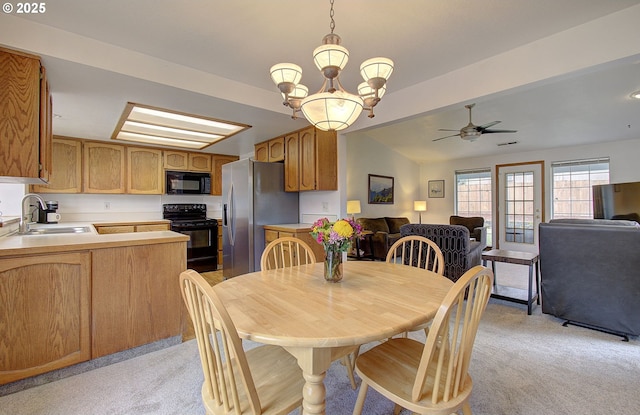 dining room featuring lofted ceiling, ceiling fan with notable chandelier, and light carpet