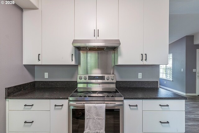 10522 SE Liebe St, Portland, OR 97266 - kitchen with electric range, under cabinet range hood, white cabinets, wood finished floors, and dark stone countertops