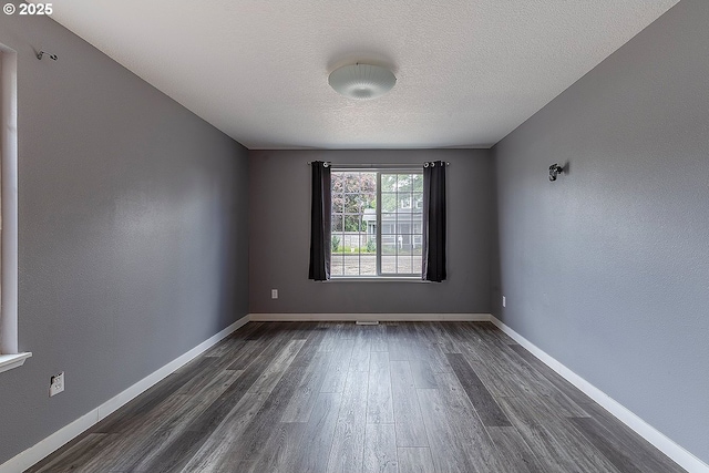 10522 SE Liebe St, Portland, OR 97266 - spare room featuring dark wood-style floors, a textured ceiling, and baseboards