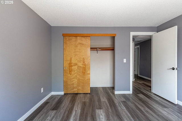 10522 SE Liebe St, Portland, OR 97266 - unfurnished bedroom with dark wood-style floors, baseboards, a closet, and a textured ceiling