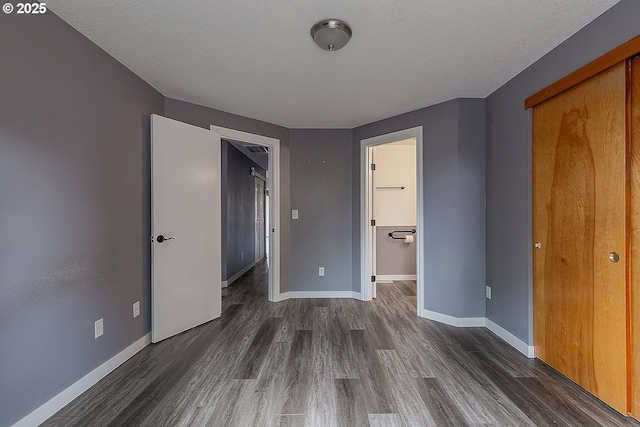 10522 SE Liebe St, Portland, OR 97266 - unfurnished bedroom featuring dark wood finished floors, baseboards, a textured ceiling, and a closet