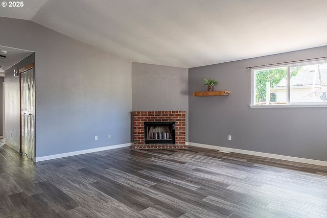 10522 SE Liebe St, Portland, OR 97266 - unfurnished living room featuring vaulted ceiling, dark wood-style flooring, a fireplace, and baseboards