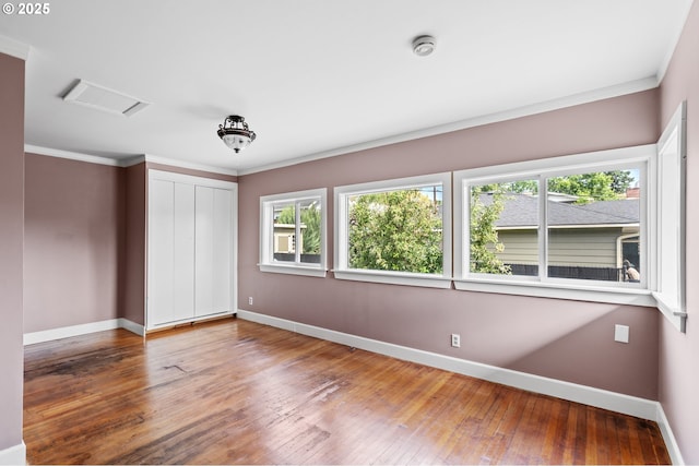 1001 NW Despain Ave, Pendleton, OR 97801 - unfurnished bedroom featuring baseboards, multiple windows, wood-type flooring, a closet, and ornamental molding