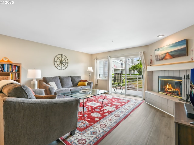 living area featuring wood finished floors and a tile fireplace