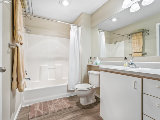 bathroom with shower / bath combination with curtain, recessed lighting, toilet, vanity, and wood finished floors