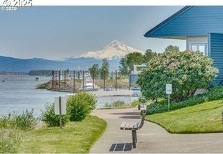 view of property's community featuring a lawn and a water and mountain view