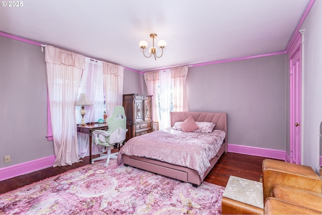 bedroom with a chandelier, baseboards, and wood finished floors