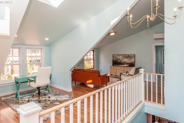 living area featuring wood finished floors, a chandelier, baseboards, recessed lighting, and a wall mounted air conditioner