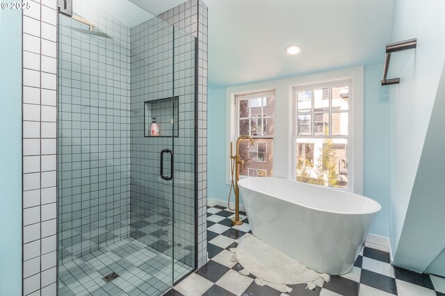full bath with a stall shower, a freestanding tub, baseboards, tile patterned floors, and recessed lighting