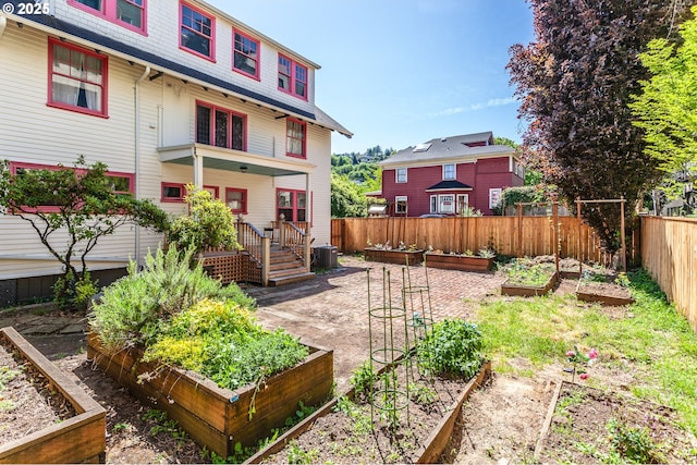 rear view of property with a garden, fence, and central air condition unit