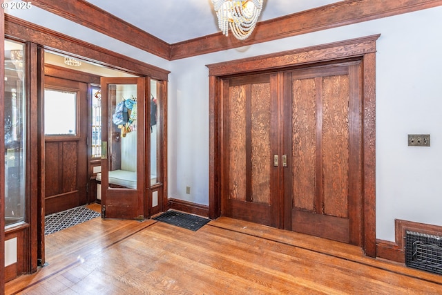 foyer with wood finished floors, baseboards, and a chandelier