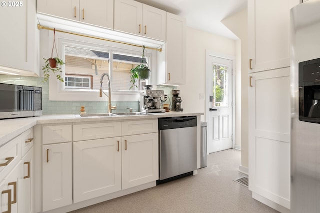 6232 NE 6th Ave, Portland, OR 97211 - kitchen featuring stainless steel appliances, a sink, light flooring, white cabinets, and light countertops