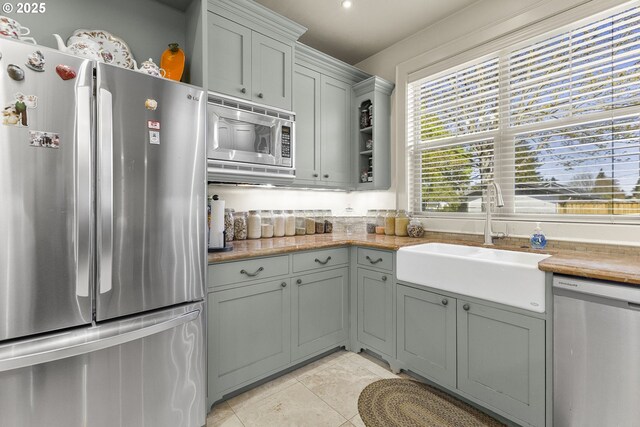 kitchen with stainless steel appliances, a sink, and light tile patterned floors