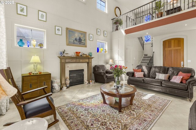 living room with stairway, a towering ceiling, and a fireplace