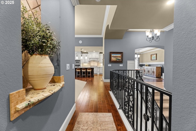 9641 SE Nicholas Dr, Happy Valley, OR 97086 - corridor featuring a chandelier, arched walkways, dark wood finished floors, crown molding, and a textured wall