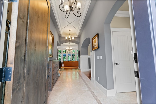 9641 SE Nicholas Dr, Happy Valley, OR 97086 - entrance foyer featuring a chandelier, arched walkways, inlaid floor details, light tile patterned flooring, and ornamental molding