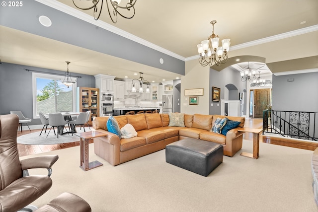 9641 SE Nicholas Dr, Happy Valley, OR 97086 - living area with a chandelier, ornamental molding, arched walkways, light wood-type flooring, and light carpet
