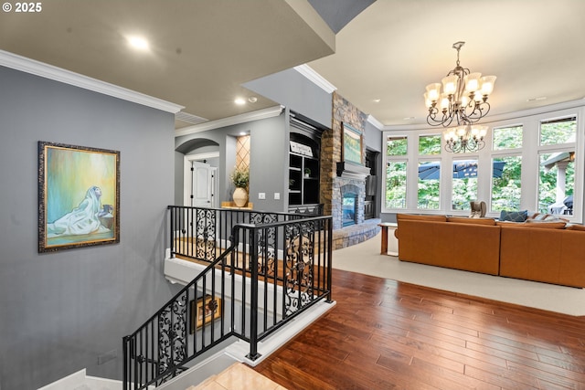 9641 SE Nicholas Dr, Happy Valley, OR 97086 - stairway with crown molding, hardwood / wood-style flooring, a chandelier, arched walkways, and a fireplace