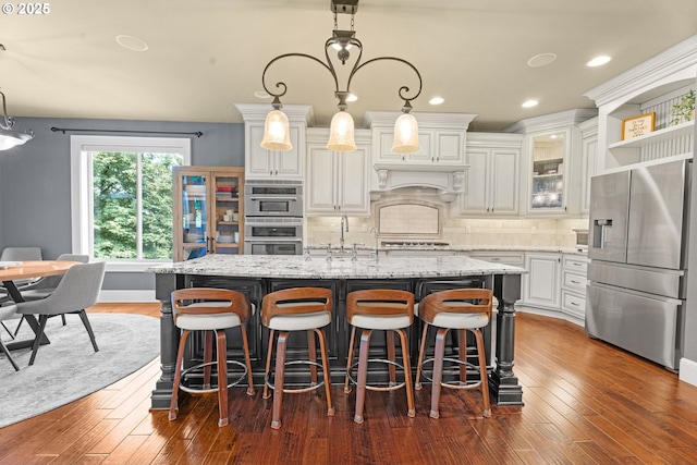 9641 SE Nicholas Dr, Happy Valley, OR 97086 - kitchen with appliances with stainless steel finishes, white cabinetry, decorative backsplash, hanging light fixtures, and light stone countertops