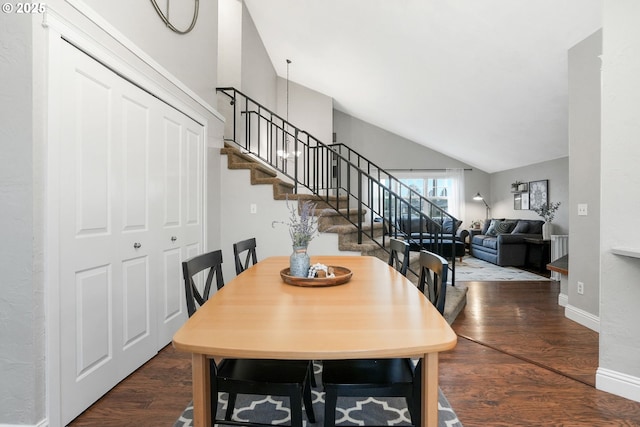 dining space featuring wood-type flooring and vaulted ceiling