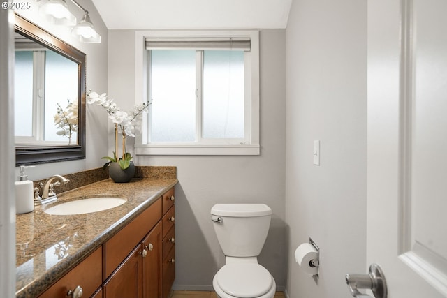 bathroom with toilet, plenty of natural light, and vanity