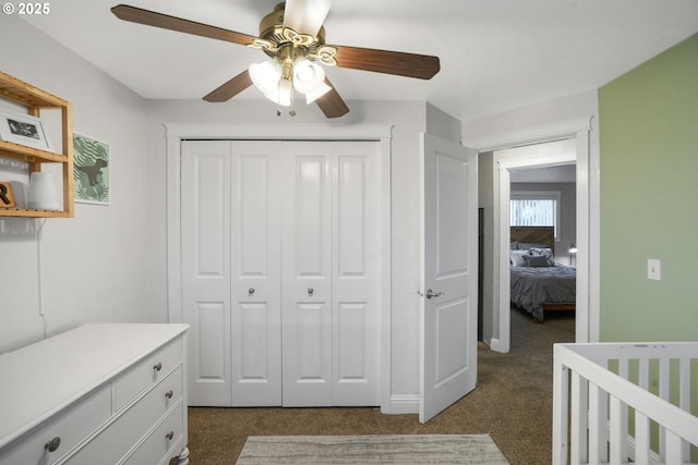 carpeted bedroom with ceiling fan, a closet, and a nursery area