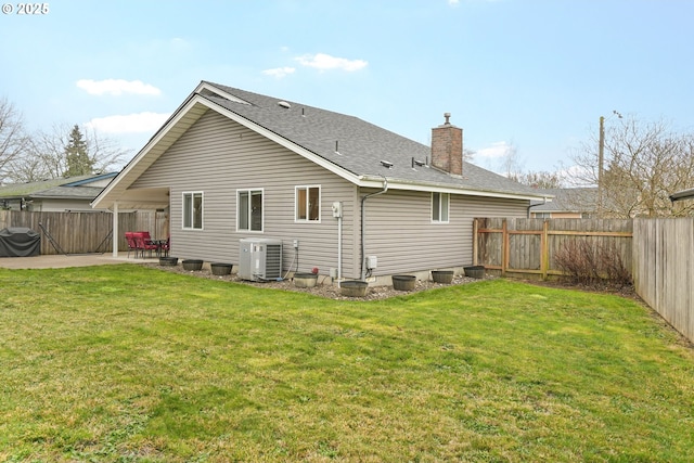 rear view of property with central AC unit, a yard, and a patio