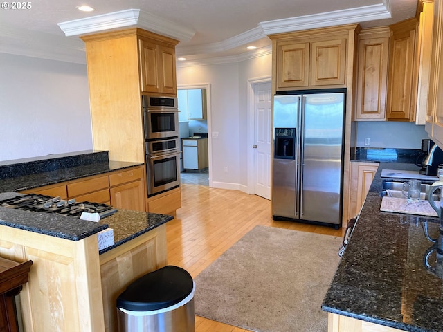 97661 Marina Heights Loop, Brookings, OR 97415 - kitchen featuring appliances with stainless steel finishes, light wood finished floors, crown molding, dark stone counters, and recessed lighting
