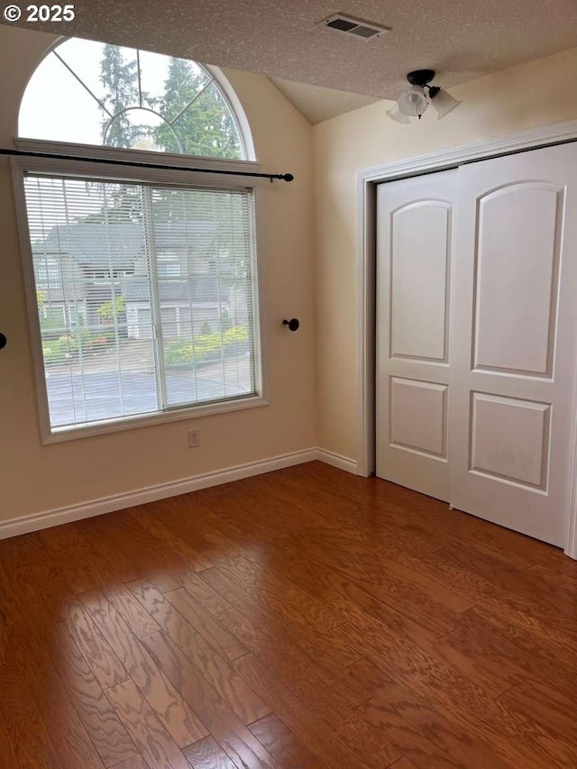 3553 NW 163rd Ct, Beaverton, OR 97006 - unfurnished bedroom with wood finished floors, lofted ceiling, a textured ceiling, and a closet