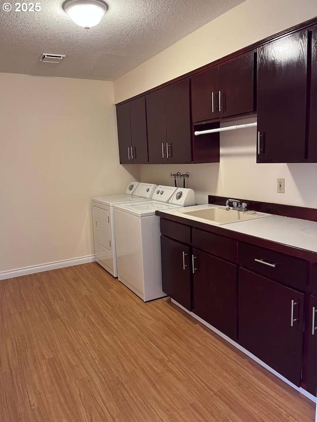3553 NW 163rd Ct, Beaverton, OR 97006 - laundry room featuring cabinet space, separate washer and dryer, light wood-style flooring, and a textured ceiling