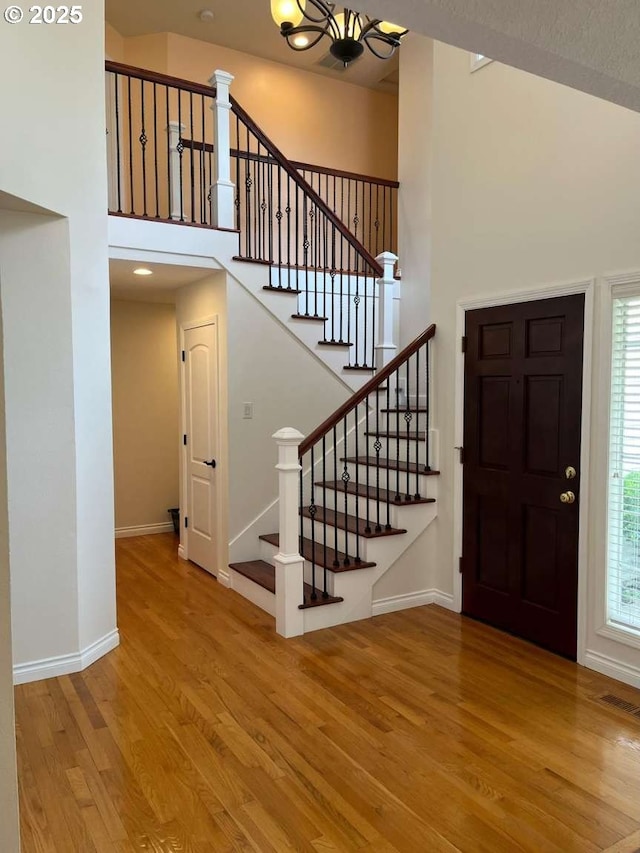 3553 NW 163rd Ct, Beaverton, OR 97006 - foyer entrance with wood finished floors, a towering ceiling, a chandelier, and stairs